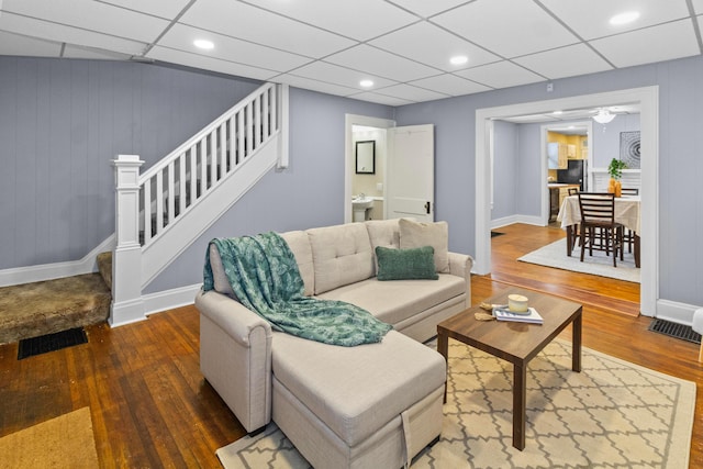 living room featuring visible vents, stairway, and wood finished floors