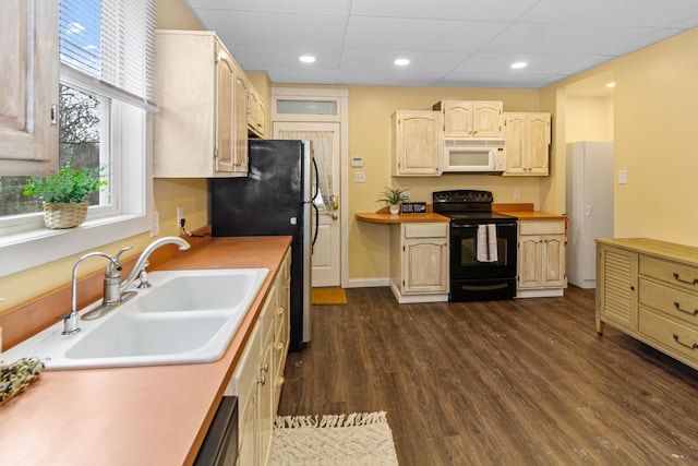 kitchen with white microwave, dark wood-type flooring, black / electric stove, light countertops, and a sink