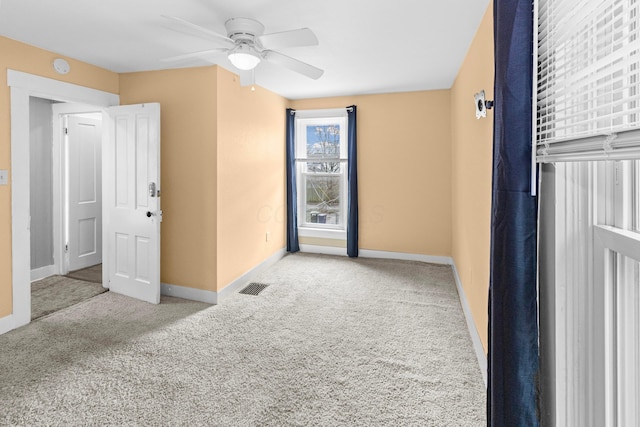 unfurnished bedroom featuring a ceiling fan, carpet flooring, visible vents, and baseboards