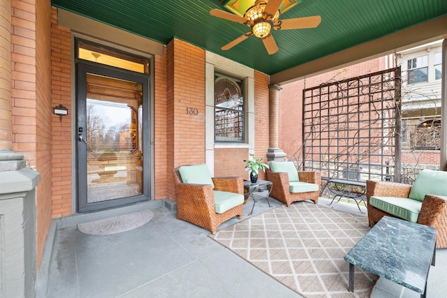 exterior space with ceiling fan, brick siding, and covered porch