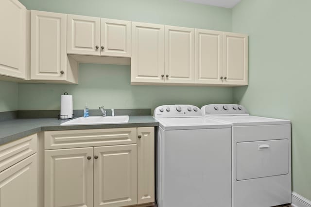 laundry room featuring cabinets, washing machine and dryer, and sink