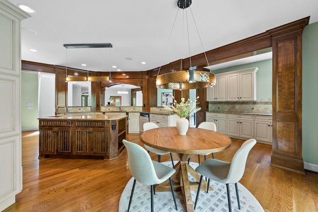 dining space with wood-type flooring and sink