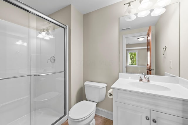 bathroom featuring tile patterned flooring, vanity, an enclosed shower, and toilet