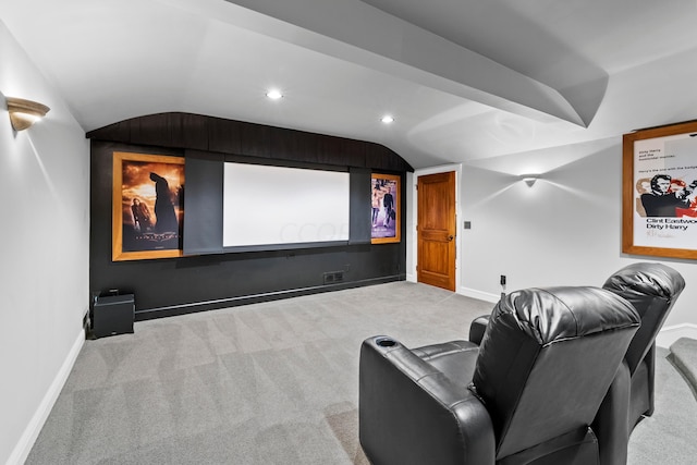 carpeted cinema room featuring vaulted ceiling