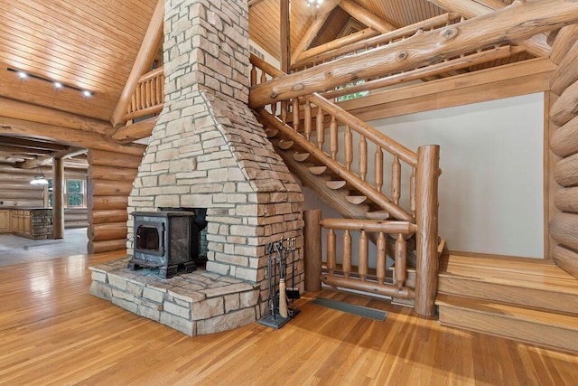 unfurnished living room with hardwood / wood-style flooring, wood ceiling, and log walls