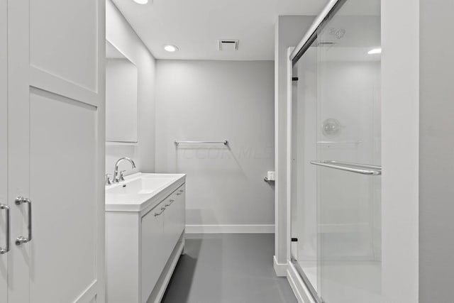 bathroom featuring vanity and a shower with door