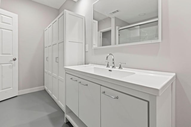 bathroom featuring vanity, an enclosed shower, and concrete flooring