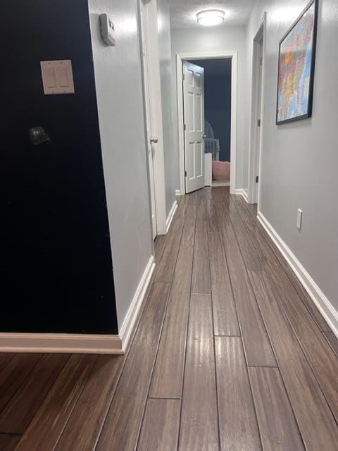 corridor with hardwood / wood-style flooring