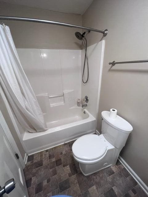 bathroom featuring toilet and shower / tub combo with curtain