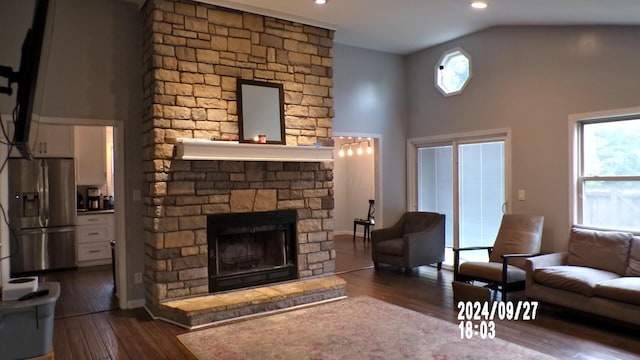 living room featuring dark hardwood / wood-style floors, a fireplace, and vaulted ceiling