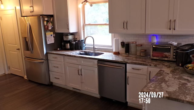 kitchen featuring light stone countertops, sink, stainless steel appliances, dark hardwood / wood-style flooring, and white cabinets