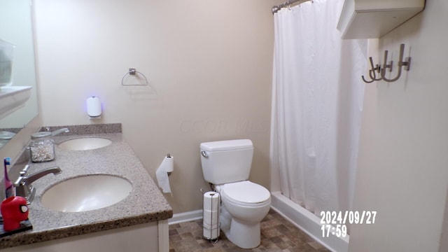 bathroom featuring a shower with shower curtain, vanity, and toilet