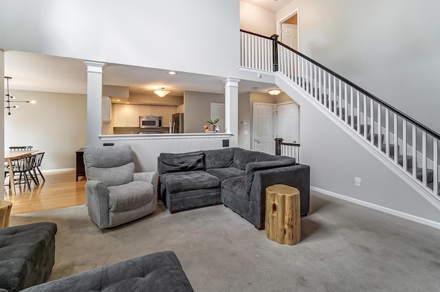 living room featuring light carpet and a towering ceiling