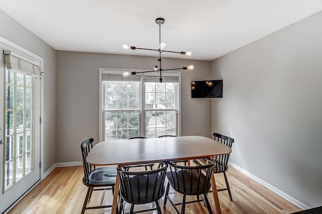 dining area featuring light hardwood / wood-style flooring and a chandelier