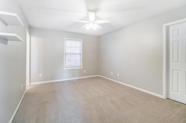 empty room featuring ceiling fan and light colored carpet