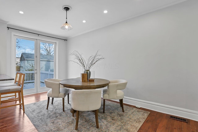 dining area featuring hardwood / wood-style flooring, crown molding, and french doors