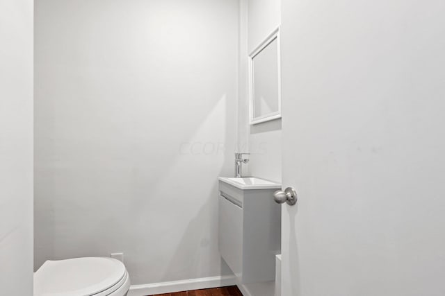 bathroom featuring vanity, hardwood / wood-style flooring, and toilet