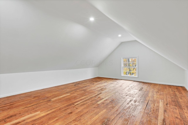 bonus room featuring lofted ceiling and light wood-type flooring