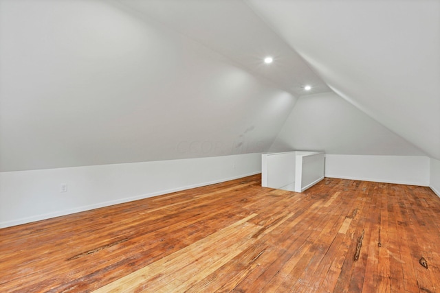 bonus room with hardwood / wood-style flooring and vaulted ceiling