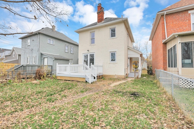 rear view of house featuring a yard and a deck