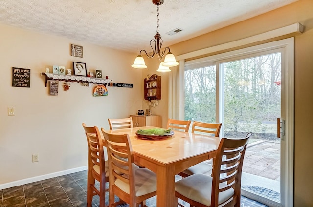 dining space with an inviting chandelier, baseboards, visible vents, and a textured ceiling