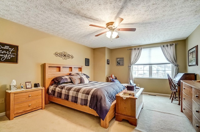 bedroom featuring baseboards, a textured ceiling, a ceiling fan, and light colored carpet