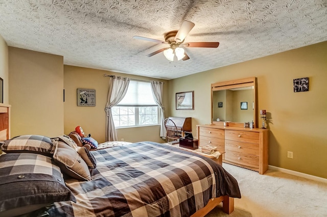 bedroom with light carpet, ceiling fan, baseboards, and a textured ceiling