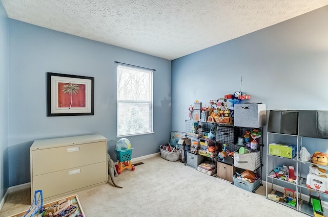 rec room with carpet, baseboards, and a textured ceiling