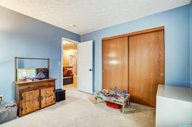 playroom with carpet floors and a textured ceiling