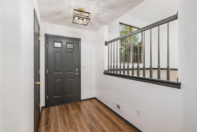 entrance foyer with a textured ceiling and dark hardwood / wood-style floors