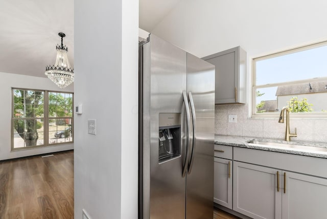 kitchen with gray cabinetry, sink, stainless steel fridge with ice dispenser, dark hardwood / wood-style floors, and decorative light fixtures