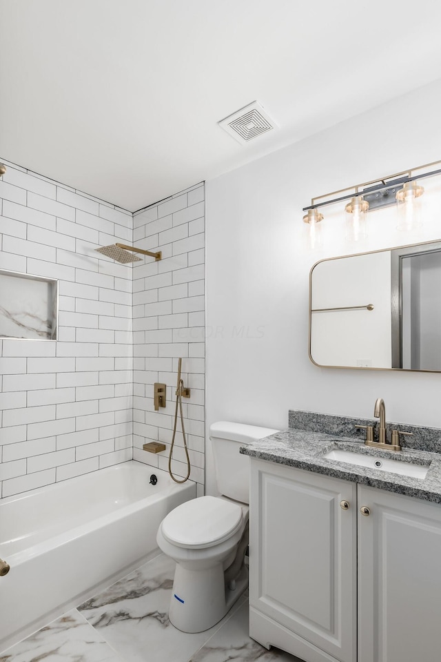 full bathroom with toilet, vanity, and tiled shower / bath