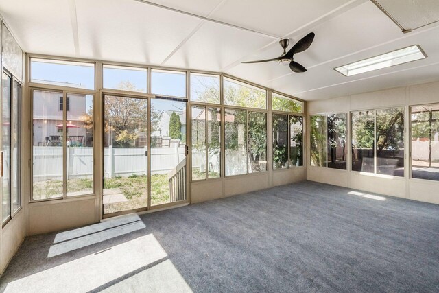 unfurnished sunroom with vaulted ceiling, a wealth of natural light, and ceiling fan