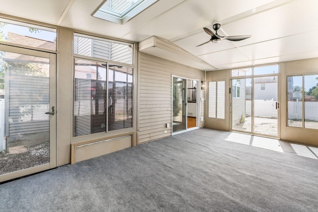 unfurnished sunroom featuring ceiling fan and vaulted ceiling with skylight