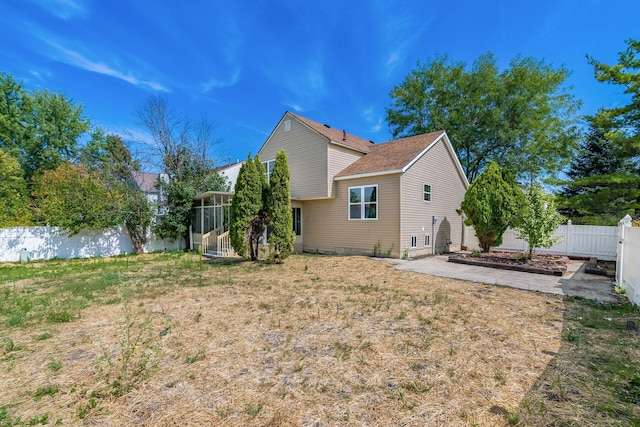 back of house with a sunroom and a yard