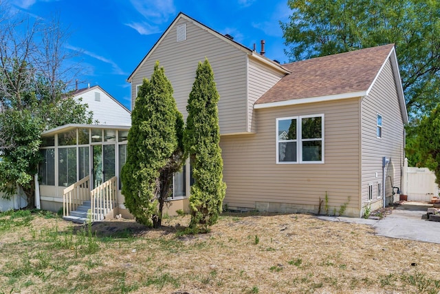 rear view of house featuring a sunroom