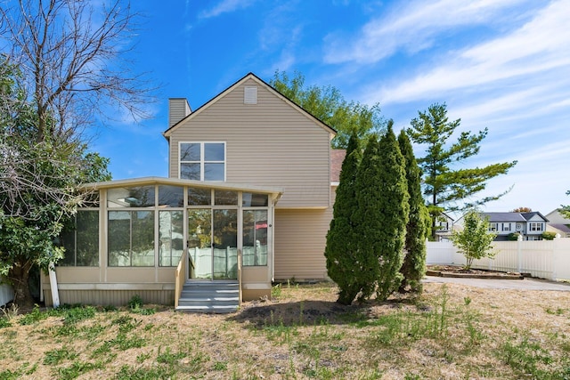 rear view of property featuring a sunroom