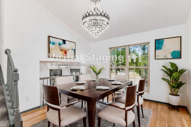 dining space featuring light hardwood / wood-style floors, vaulted ceiling, and a notable chandelier