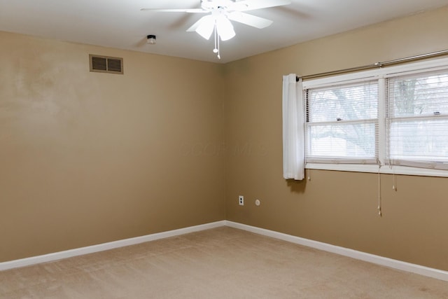 carpeted spare room with ceiling fan