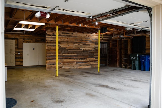 garage with a garage door opener and wood walls