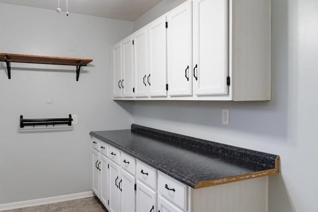 clothes washing area with light tile patterned floors