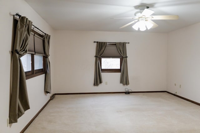 spare room with ceiling fan and light carpet