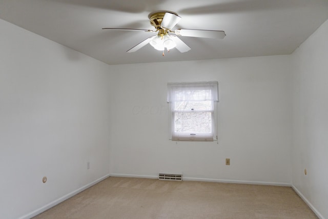 spare room featuring light colored carpet and ceiling fan