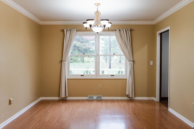 unfurnished room featuring crown molding, light hardwood / wood-style flooring, and a notable chandelier