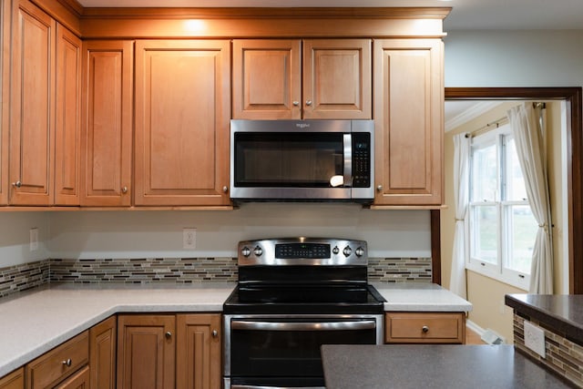 kitchen with appliances with stainless steel finishes and backsplash