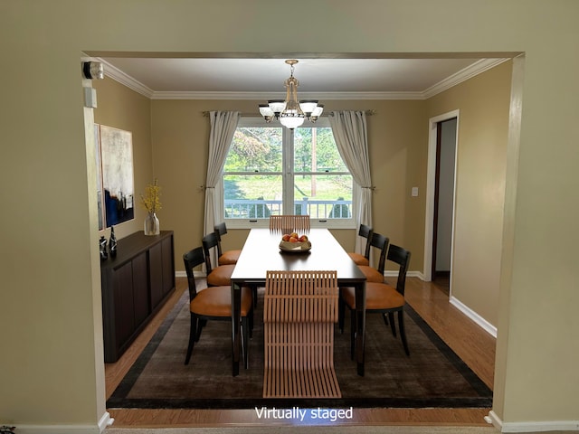 dining room with ornamental molding, hardwood / wood-style floors, and a chandelier