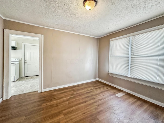 empty room with hardwood / wood-style flooring, ornamental molding, and a textured ceiling