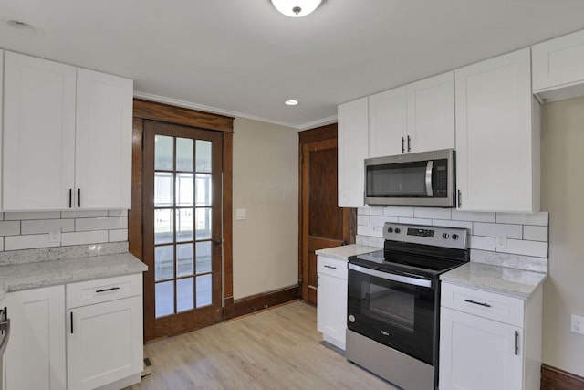 kitchen with backsplash, white cabinets, stainless steel appliances, and light wood-type flooring