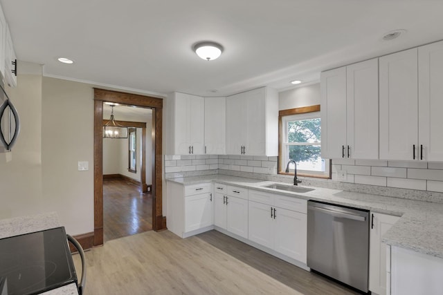 kitchen featuring sink, tasteful backsplash, stainless steel dishwasher, light hardwood / wood-style floors, and white cabinets