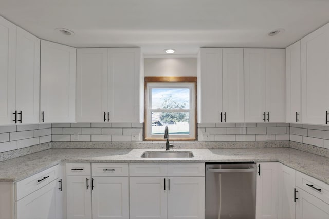 kitchen featuring stainless steel dishwasher, white cabinetry, and sink